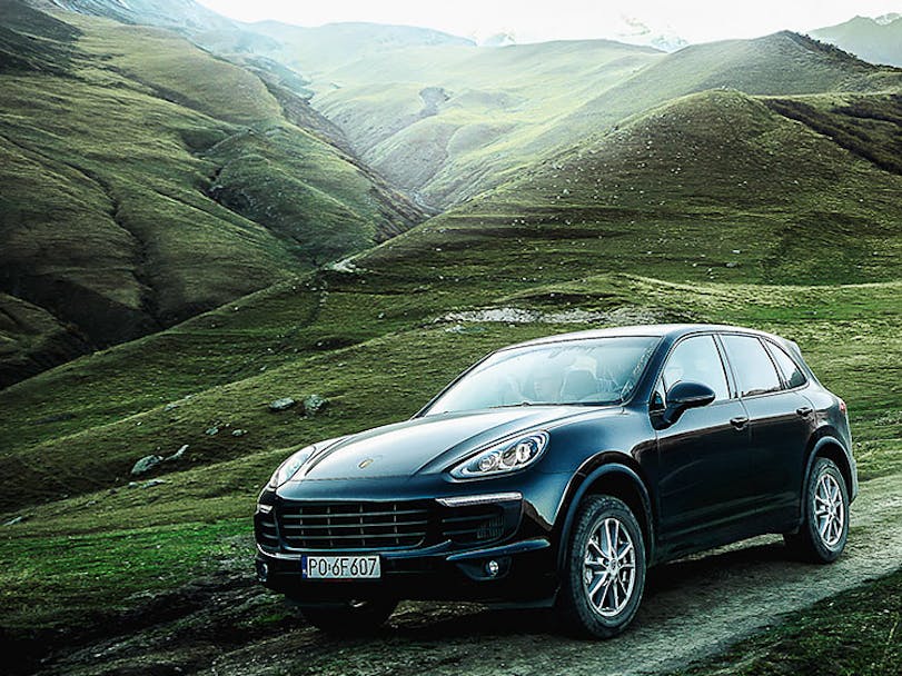 Black Porsche Cayenne in a pristine mountain landscape