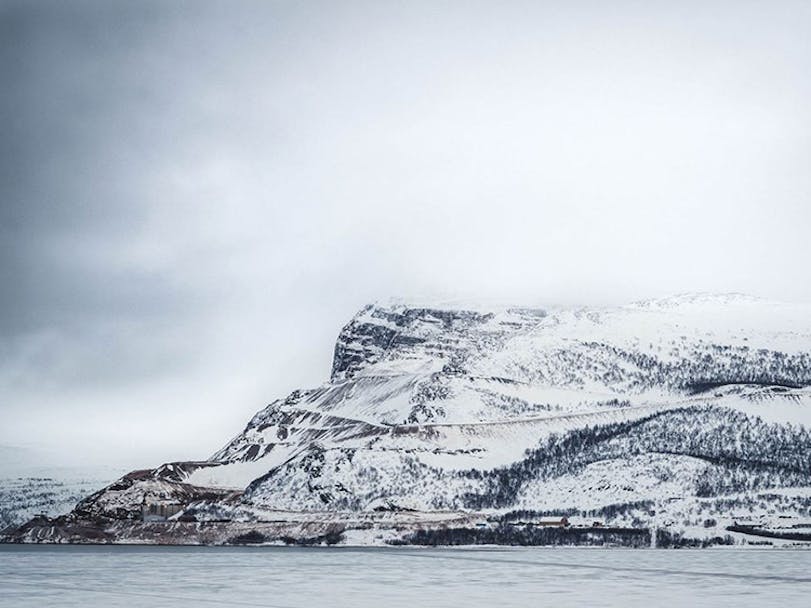 Snowy cliff at North Cape under grey skies